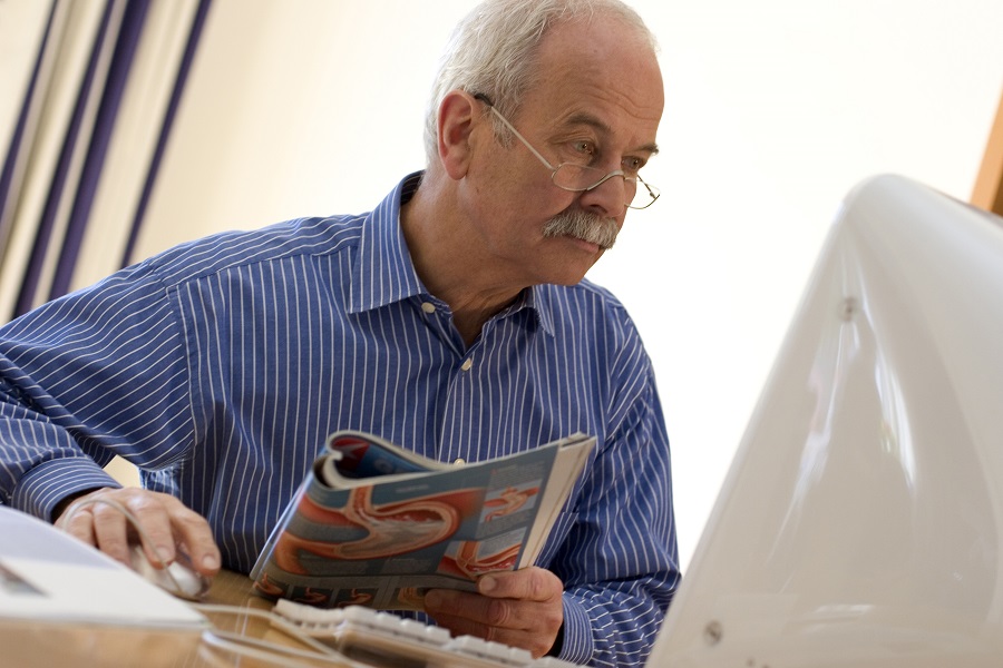 Älterer Mann informiert sich am Computer