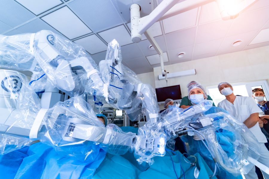 Gro&szlig;aufnahme von in Folie verpackten medizintechnischen Ger&auml;ten, im Hintergrund medizinische Fachkr&auml;fte mit Gesichtsmaske