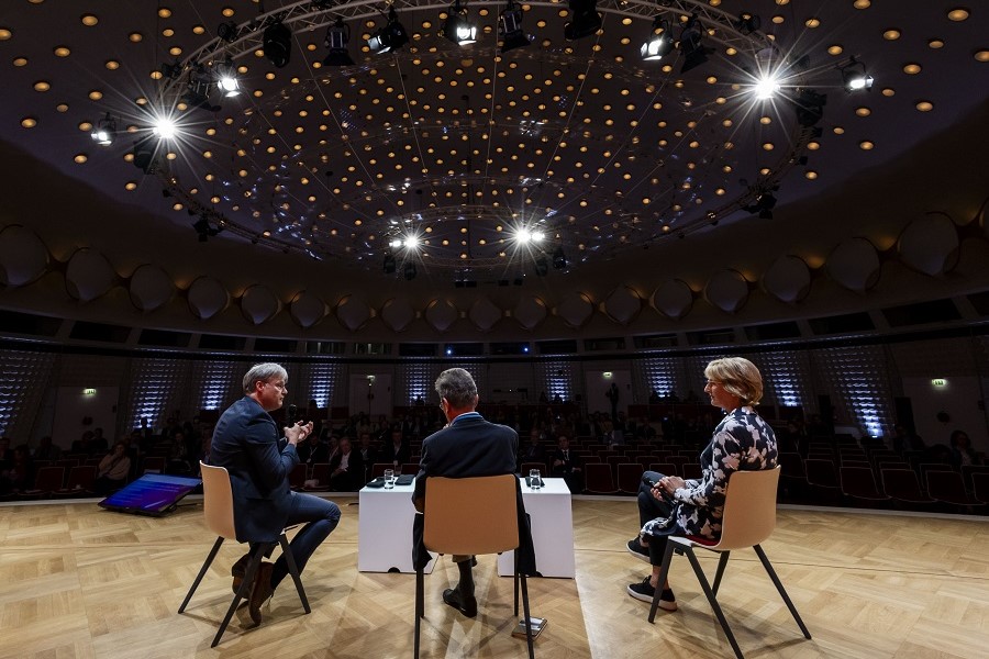 Professor Quante, Dr. Huber und Professorin Woopen auf der Bühne während der Konferenz 