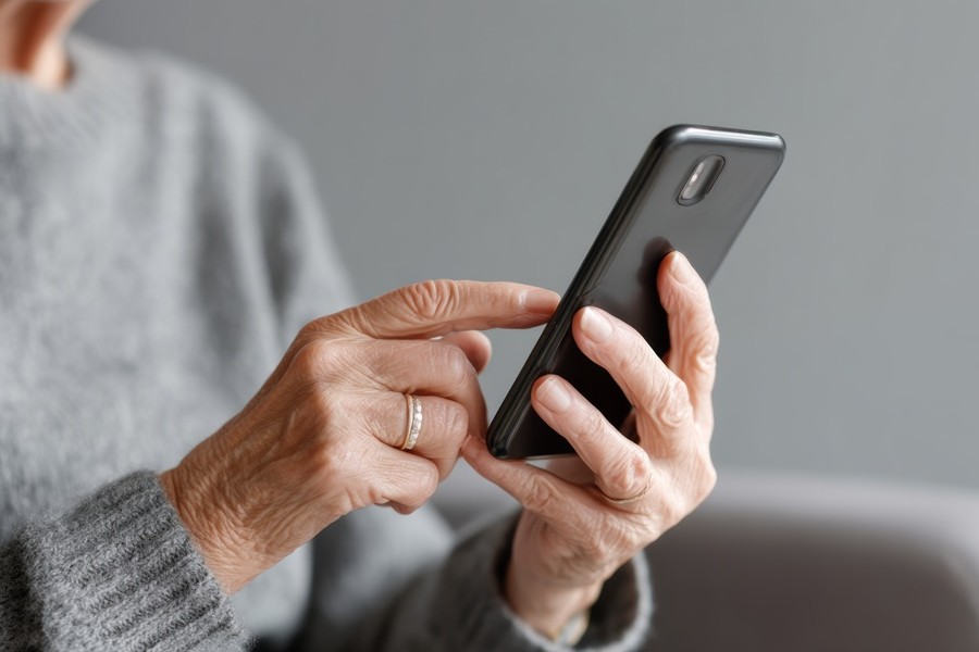 Eine ältere Dame hält ein Smartphone in der Hand Eine ältere Dame hält ein Smartphone in der Hand.