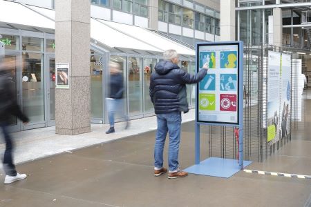 Ein Passant betrachtet das Medienterminal der Ausstellung. 