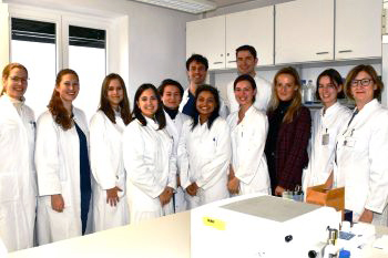 Aufnahme eines Forschungsteams in wei&szlig;en Kitteln im Labor