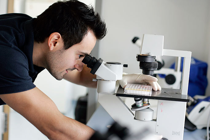 Forscher sieht durch Mikroskop