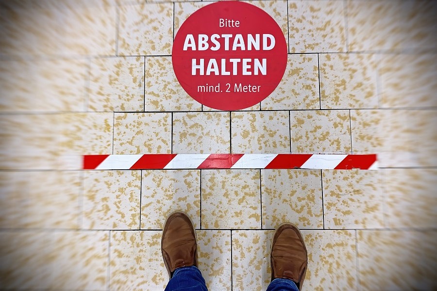 Symbol “Abstand halten” auf einem Fußboden 