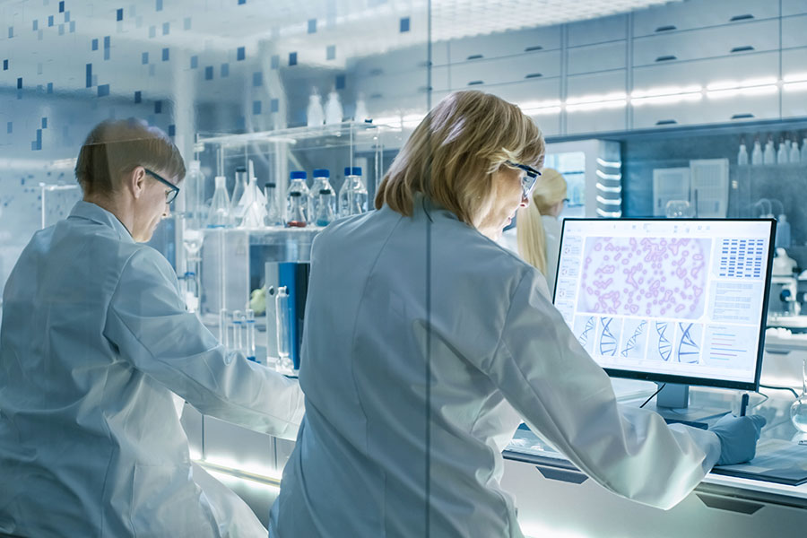Wissenschaftleirnnen und Wissenschafter an Computerarbeitsplätzen im modernen Labor