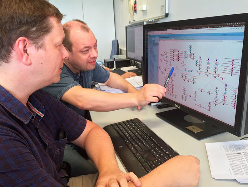 Zwei Wissenschaftler bei der Diskussion &uuml;ber das Alacris-ModCell-Modellierungssystem am Computer
