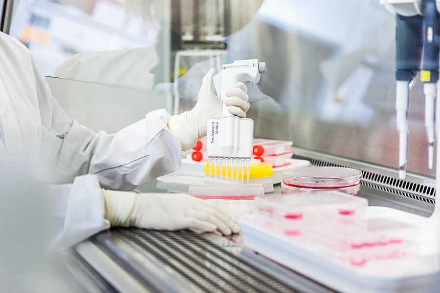 Frau mit Handschuhen pipettiert Proben im Labor Frau mit Handschuhen pipettiert Proben im Labor