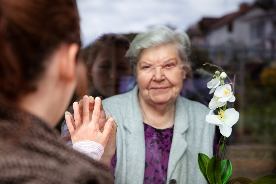 Zwei Frauen getrennt durch Fensterscheibe 