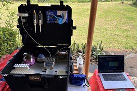 Ein Koffer mit einem kleinen, voll funktionsfähigen Labor, daneben steht ein aufgeklapter Laptop