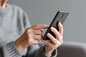 Eine ältere Dame hält ein Smartphone in der Hand