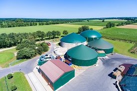 Eine Biogasanlage umgeben von grünen Feldern