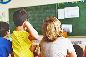 Schulinder schauen auf Tafel