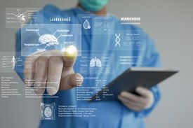 Mann in Operationskleidung mit Tablet in der Hand zeigt auf halbtransparente Datensätze.
