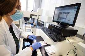 Eine Wissenschaftlerin beim robotisch assistierten Ausstanzen von Trockenblutproben (DBS)