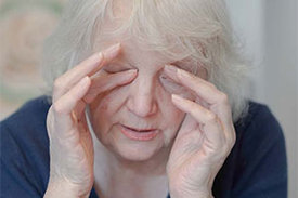 Frau reibt sich die Augen mit beiden Händen