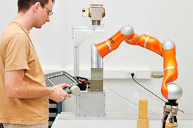 Mit diesem Roboterarm arbeiten Professor Schöner und sein Team. Durch eine Kamera und verschiedene Sensoren ist er in der Lage, auf Änderungen in der Situation zu reagieren.