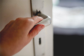 Hand umfasst Türklinke