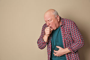 Älterer hustender Mann