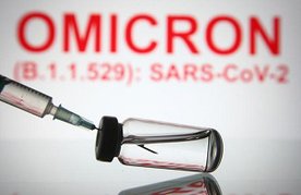 Impfstoffampulle vor Schriftzug OMICRON